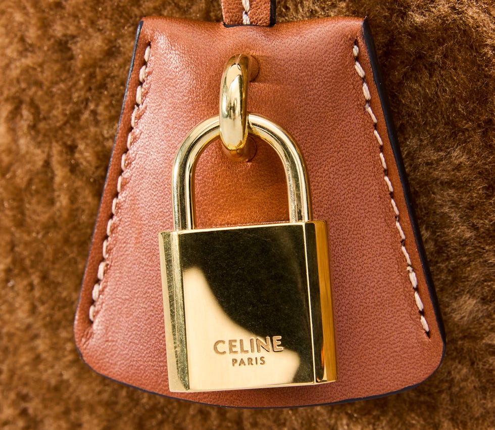 A padlock attached to a leather accessory with branding.