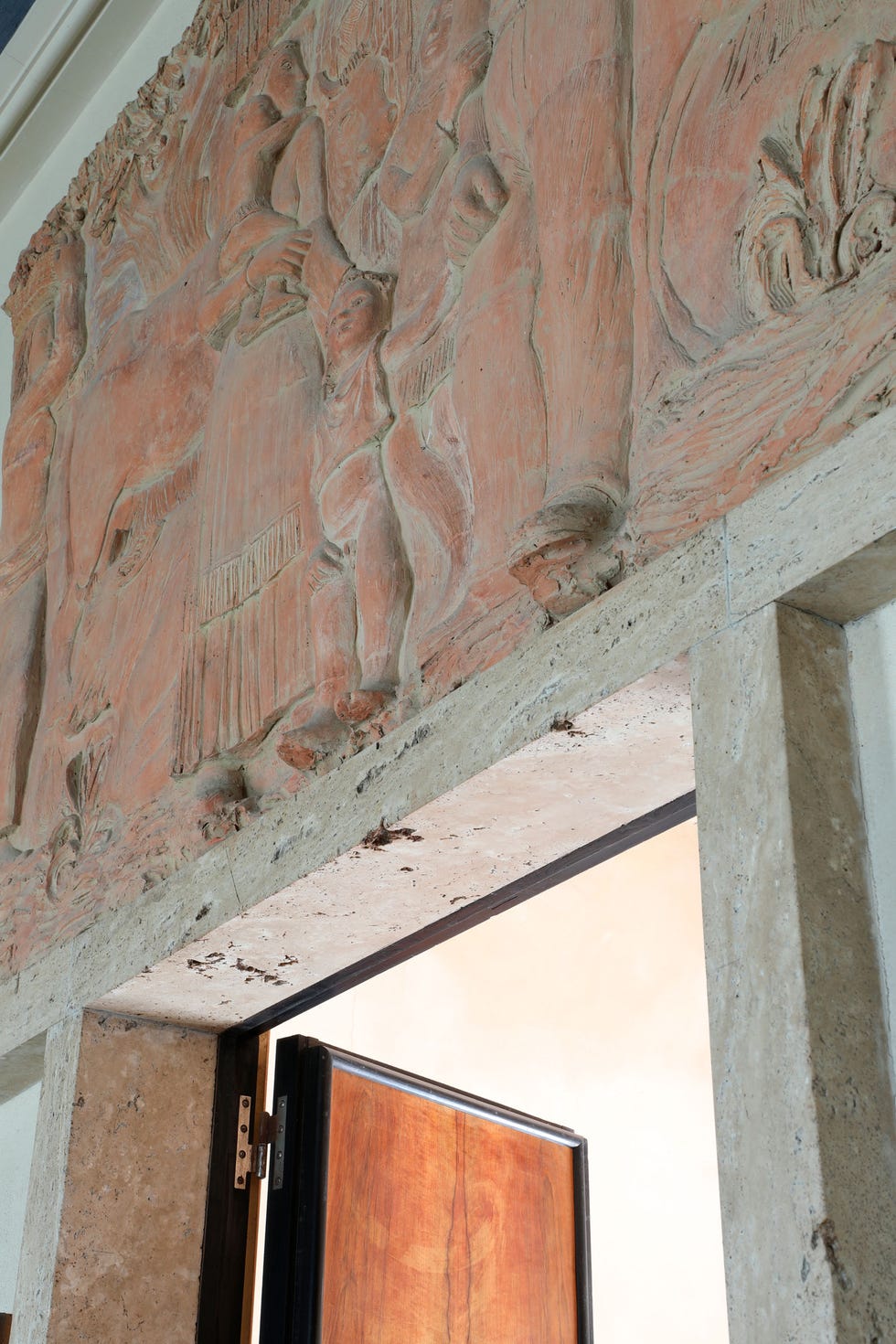 Carved relief above a doorway depicting human figures and natural elements.