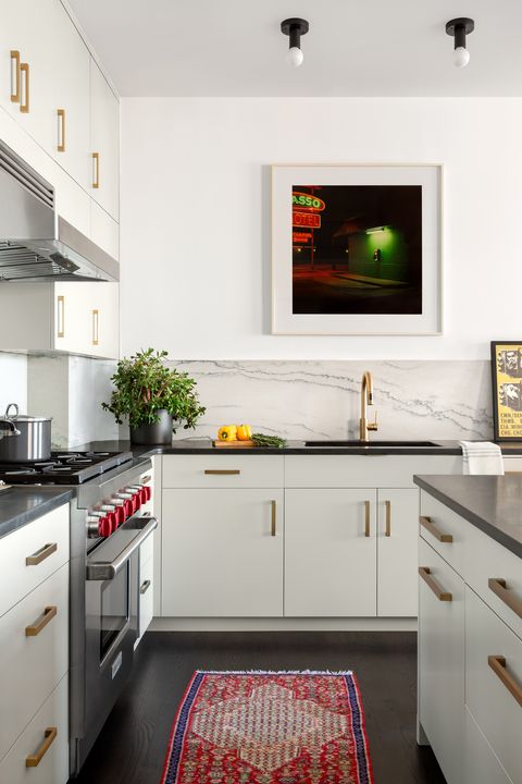 white kitchen, black countertops, rug, gold handles