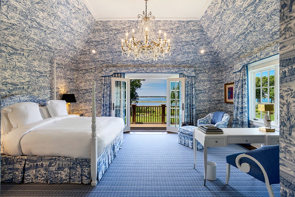 bedroom with wallpaper and a chandelier