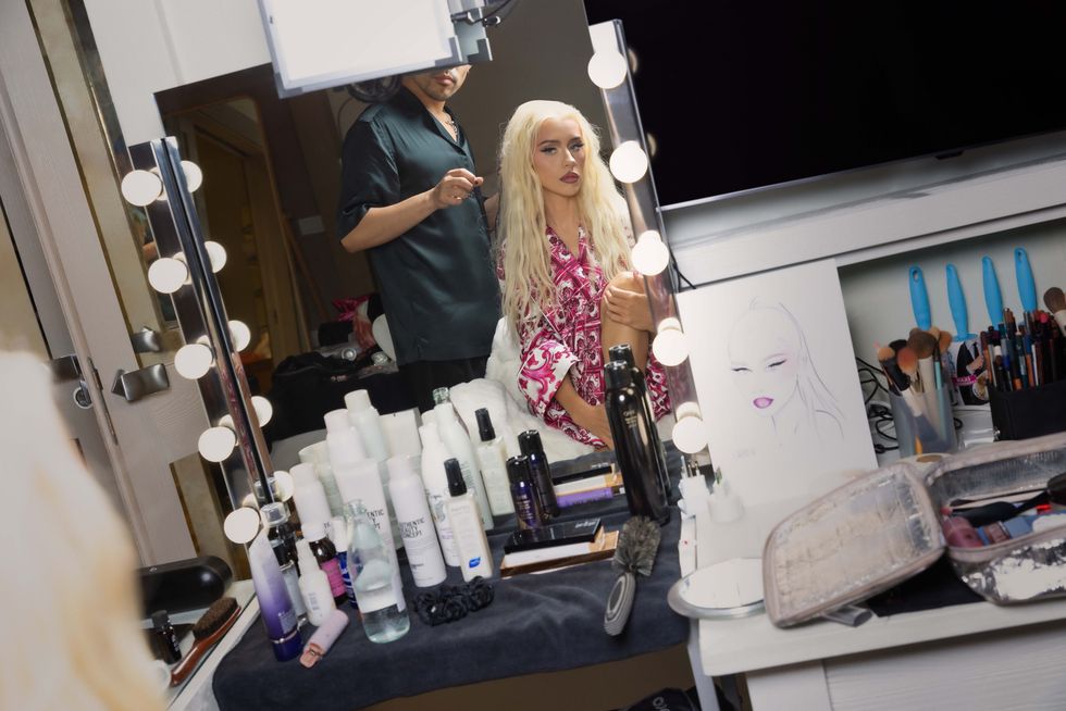 christina aguilera looking at her reflection in a mirror as she gets ready for a performance