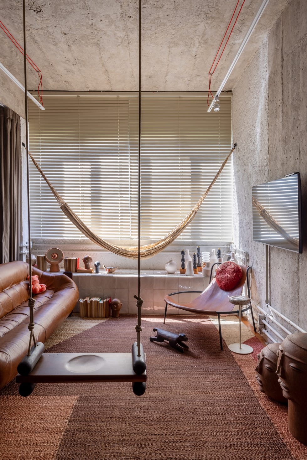 esta casa de 45 metros cuadrados es un estudio de arquitectura, un taller creativo y una zona de relax con hamaca, columpio y un bano triangular