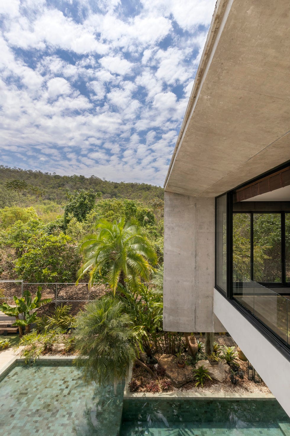 casa de hormigon con piscina que combina estructura brutalista, ventilacion cruzada y diseno tropical a medida