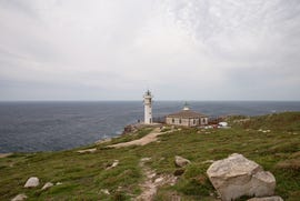 a lighthouse on a hill by the water