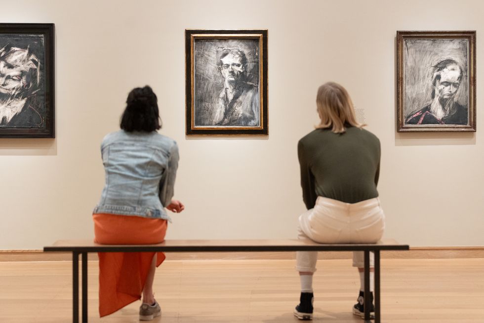 two women looking at art on the wall