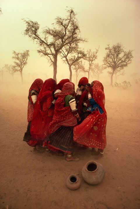 Vrouwen in India schuilen bij elkaar tegen een zandstorm
