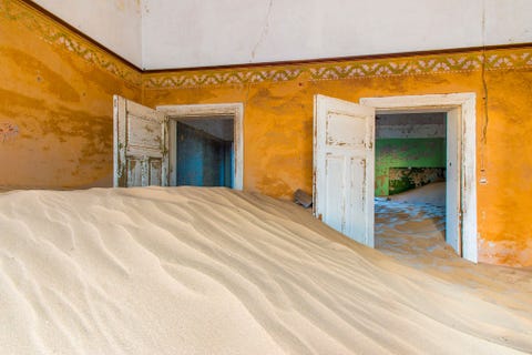 KOLMANSKOP NAMIBI  Woestijnzand overstroomt verlaten gebouwen in een voormalige diamantstad  ooit een van de rijkste plaatsjes ter wereld  die zijn rijkdommen al in de jaren dertig van de vorige eeuw heeft prijsgegeven