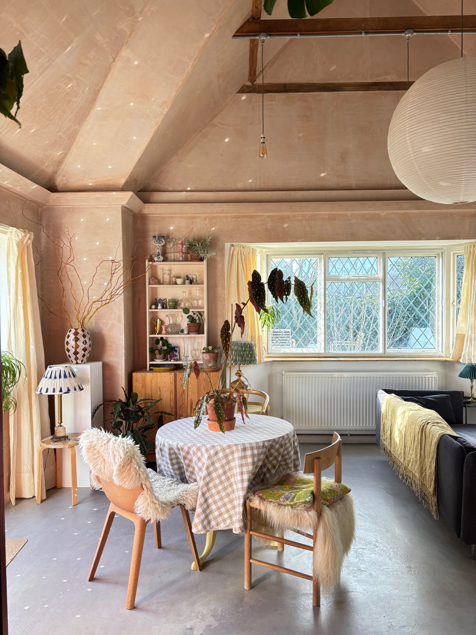a sunlit open plan room filled with budget and luxury furniture including a sofa and dining table