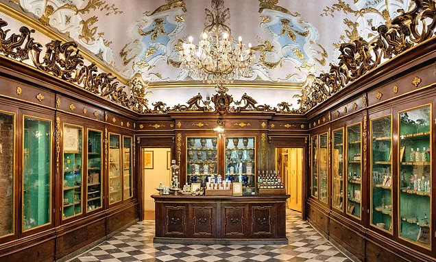Historic pharmacy interior with wooden display cabinets and elaborate decor.