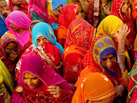 Dicht opeengepakt lopen vrouwen in felgekleurde saris mee in een bruidsstoet in Mandawa Rajasthan Rajasthan is de grootste deelstaat van India en een land van extremen met tropische wouden droge steppen en de besneeuwde pieken van de Himalaya