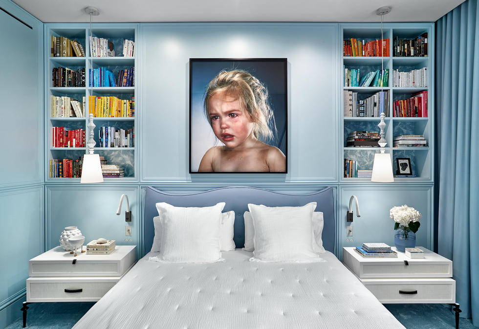 une chambre bleue avec un portrait d'enfant perplexe