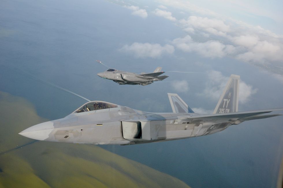 a f 22 raptor from the 325th fighter wing flies alongside a f 35 lightning ii from the 33rd fighter wing over the emerald coast the fifth generation fighter jets flew together in a rare dissimilar formation to salute healthcare workers, first responders and other essential employees may 15, 2020 us air force photo by 1st lt savanah bray