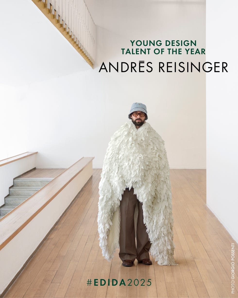 A person in a unique fashion piece standing in a minimalist interior.