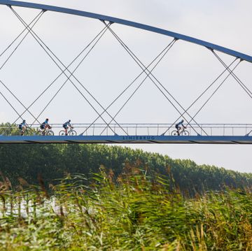 groep wielrenners fietsend over een brug