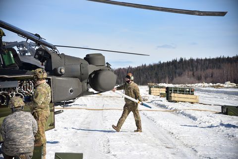 spc cody brunner, d company, 1st battalion, 25th aviation regiment, carries a 275 inch rocket to load into an ah 64 apache helicopter at the firebird lz forward arming and refueling point in the yukon training area near fort wainwright april 13, 2021 support crews from the 1 25th arb set up the farp for the battalion’s live fire aerial gunnery on mcmahon range april 12 22 army photojohn pennell