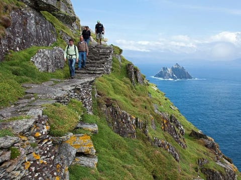 Skellig Michael Gebouwd op een steile rots met twee pieken die ongeveer 11 kilometer van de kust ligt van Count Kerry is het klooster van Skellig Michael het toonbeeld van de extremen van vroege Christelijke aanbidding en discipline Monniken woonden mogelijk vanaf de zesde eeuw tot in de dertiende eeuw op het eiland en ze bouwden er de smalle stenen terrassen op zon 150 meter boven het water voor hun bijenkasten oratoriums en tuinen met kanalen en waterbakken om regenwater op de vangenDe uitgebreide bouwwerken van steen waaronder een aantal bijna verticale trappen dienden als boetedoening en waren praktisch tegelijk Op de zuidpunt moesten de monniken voor een devotieroute over de rotsen klimmen om bij een aantal gebedsplaatsen te komen op richels voor ze bij hun eindpunt aankwamen een grote steen waarop een kruis is uitgehakt op een rots klif ongeveer 213 meter boven de zee die alleen bereikt kan worden met doodsverachting langs het pad voor vergevingHet zal je niet verbazen dat Skellig Michael een UNESCO World Heritage locatie is Het is ook een vogelspottersplek vanwege een grote kolonie papegaaiduikers Zelfs vandaag de dag is het niet eenvoudig om op Skellig Michael te komen omdat boten alleen op kalme zee kunnen aanmeren Boten vertrekken vanaf Ballinskelligs en Portmagee Er is een bezoekerscentrum op het Valentiaeiland