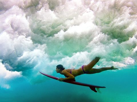 De Australische longboarder Belinda Baggs duikt onder een golf door tijdens het surfen in Queensland Gold Coast is een surfparadijs waar grommets Australische slang voor surfers hun kunsten vertonen op de golven van beroemde surfstranden als de Spit Surfers Paradise en Mermaid Beach