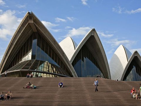Het Sydney Opera House is een icoon van de grootste stad van Australi en beschikt over verschillende zalen voor diverse soorten amusement Het kenmerkende dak van het operagebouw bestaat uit tegen elkaar geplaatste schelpen die een getrapt platform vormen waar voetgangers kunnen genieten van de zon