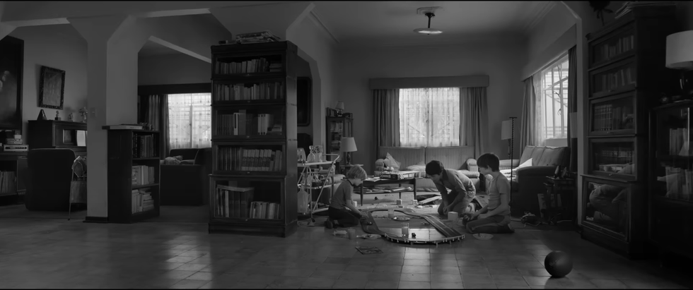 Children playing with a train set in a living room.