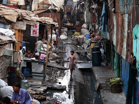 A young girl walks through Mumbais Dharavi slum home to about a million people Many Indians live in modern suburbs and work in gleaming skyscrapers but many morea large majorityremain impoverished and trapped by tradition