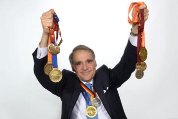 individual holding multiple medals and ribbons aloft