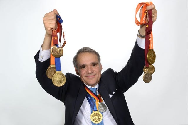 individual holding multiple medals and ribbons aloft