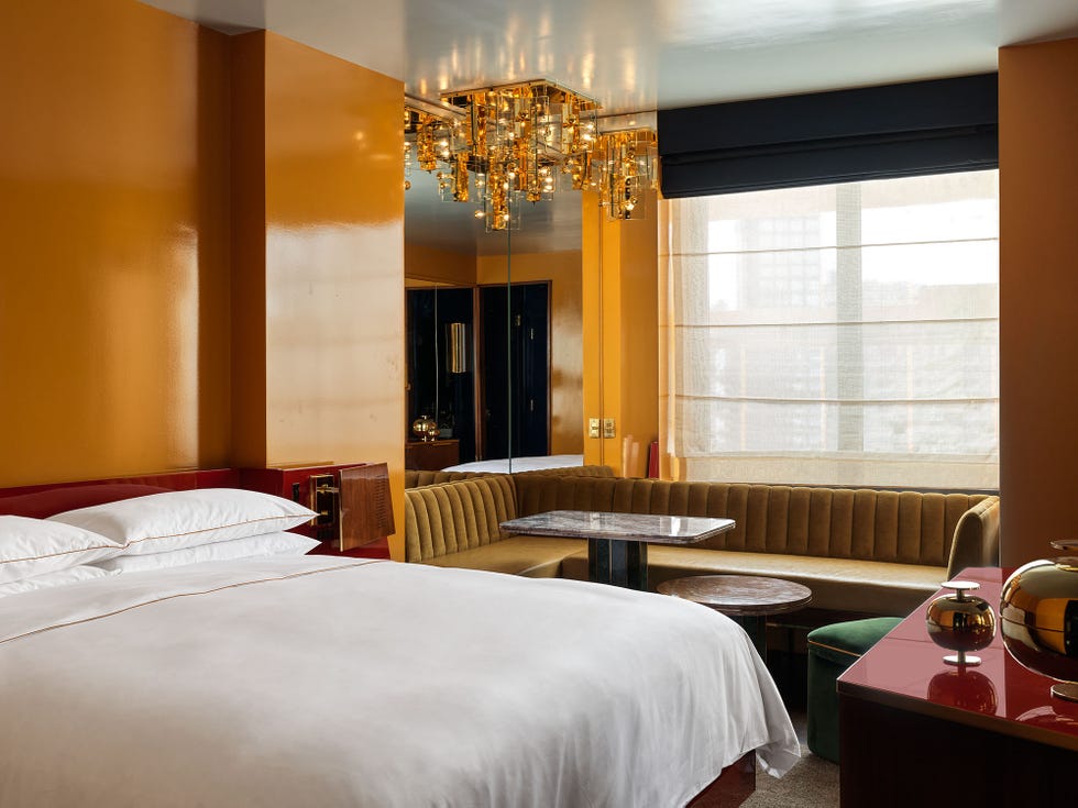 a modern hotel room featuring a bed, seating area, and decorative elements
