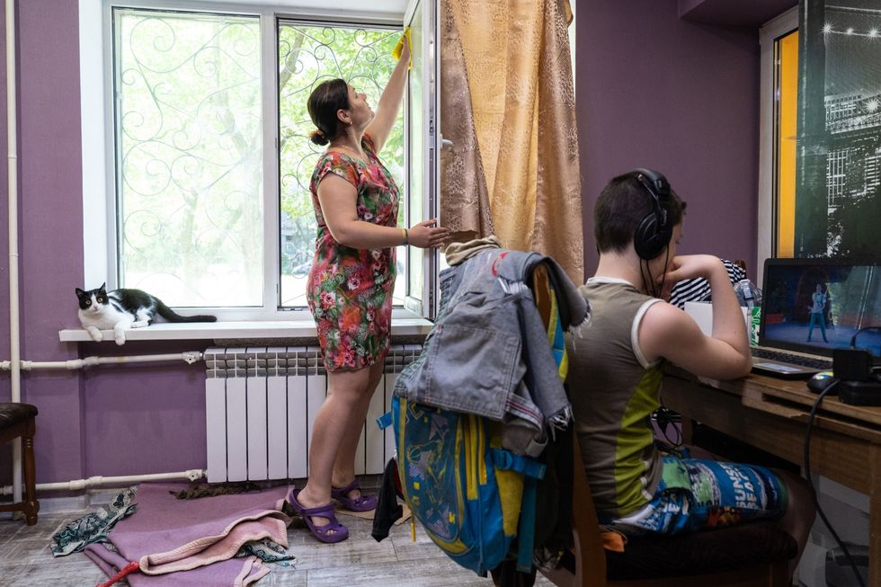 Nadya Fedun wast de ramen van haar woning in het centrum van Marioepol Net als andere inwoners van de stad klaagt ze over het alomtegenwoordige grafietstof afkomstig van de ijzer en staalfabrieken in de stad Morgen zijn de ramen alweer vies zegt ze