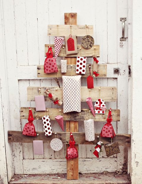 wood pallet advent christmas tree with red and white packages pinned to it