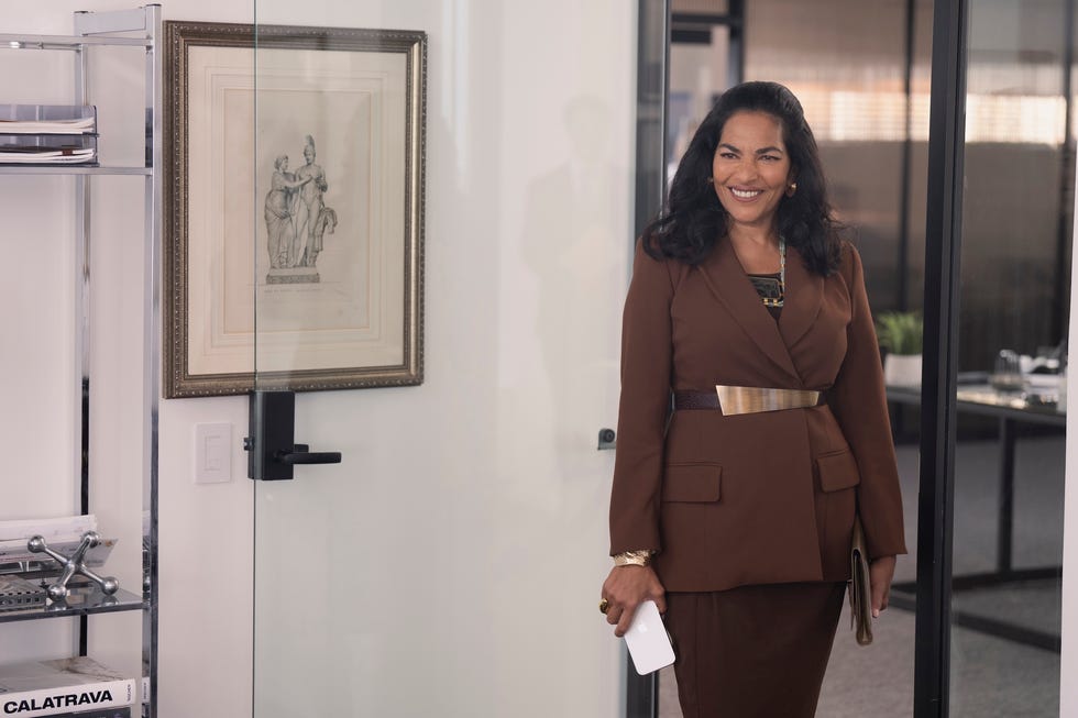 An individual in a professional setting wearing a brown suit.