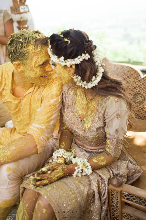 Yellow, Sitting, Tradition, Interaction, Bridal clothing, Headgear, Temple, Bride, Marriage, Hair accessory, 