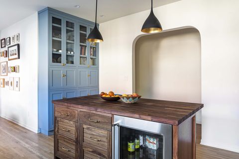 white kitchen with arch and dark wood butcher block island