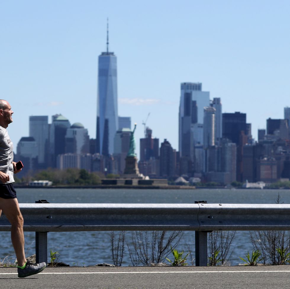 jeff dengate runs at port jersey, with new york city and the statue of liberty in the background