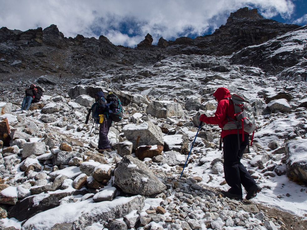 Een reisbegeleider begeleidt een groep naar de top van het Himalayagebergte