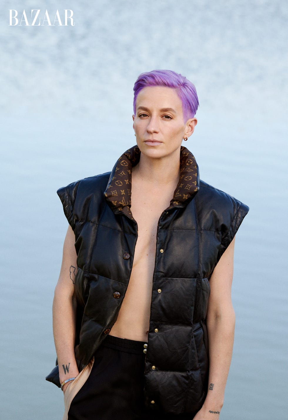 megan wears a puffer jacket standing in front of water