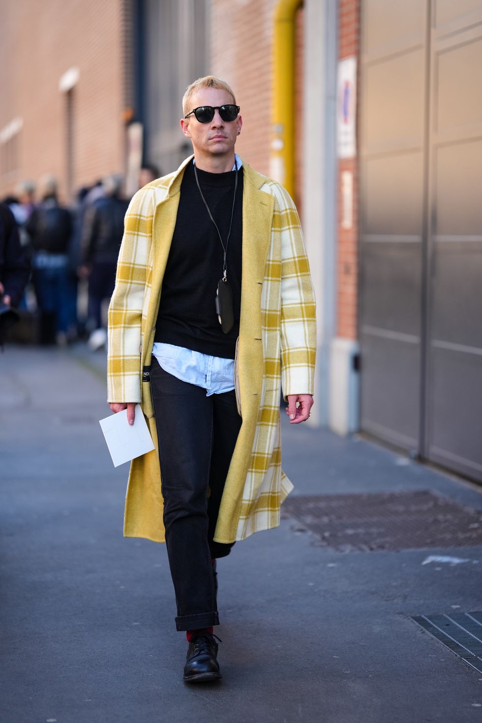 milan, italy january 13 a guest wears sunglasses, a black pullover, a yellow and white trench coat, black pants, outside fendi, during the milan fashion week menswear fallwinter 2024 2025 on january 13, 2024 in milan, italy photo by edward berthelotgetty images