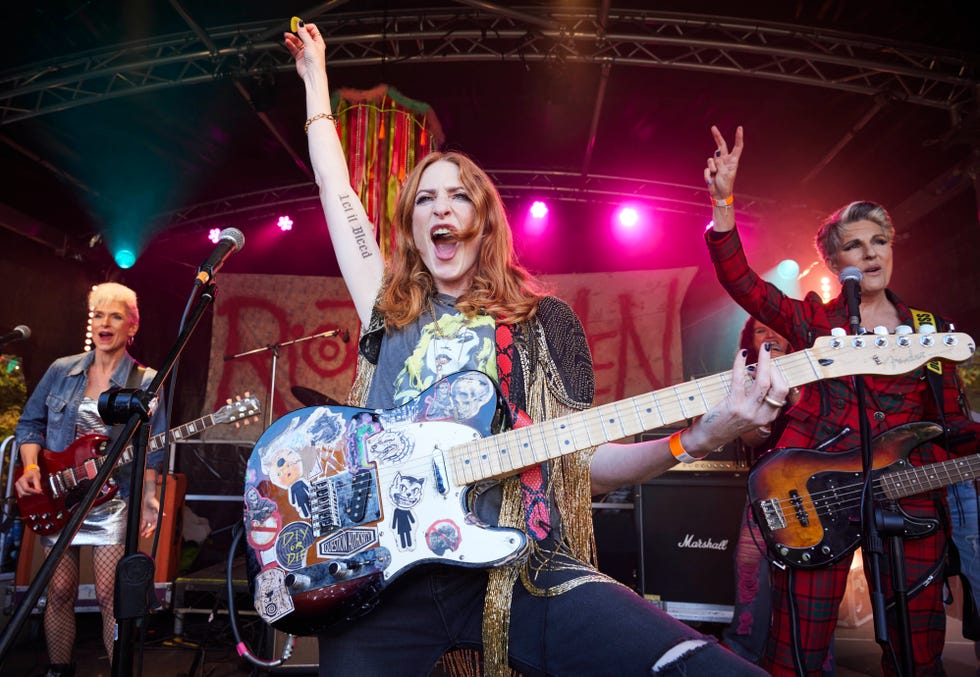 Band performing on stage with electric guitars and vibrant lighting