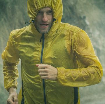een man loopt hard in de regen