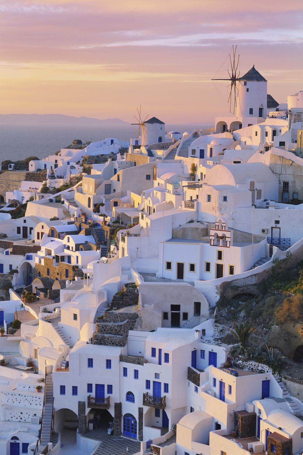 view of oia with traditional greek windmills, sunset, santorini, cyclades, mediterranean sea, greece