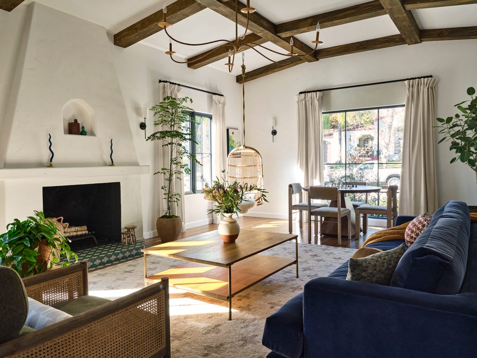 a bright and airy living room characterized by high ceilings with exposed wooden beams