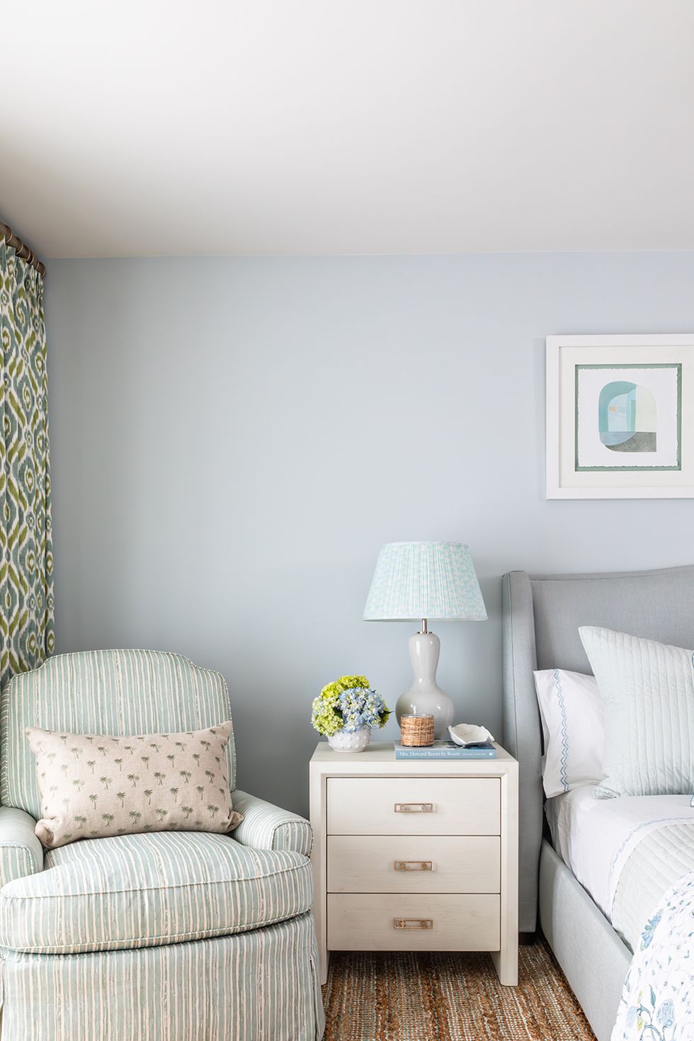 bedroom with accent chair and blue and green curtains