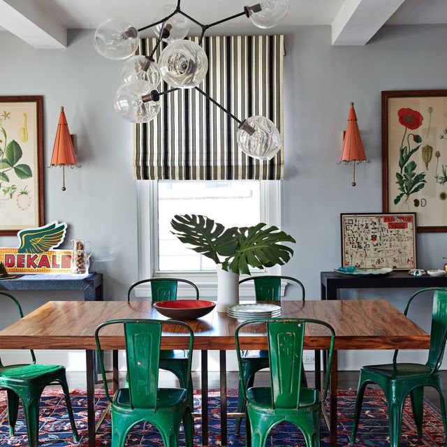 colorful dining room with green chairs and vintage art