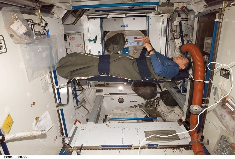In de verbindingsmodule Harmony van het ISS rust astronaut Paolo Nespoli van de European Space Agency ESA uit in zijn slaapzak