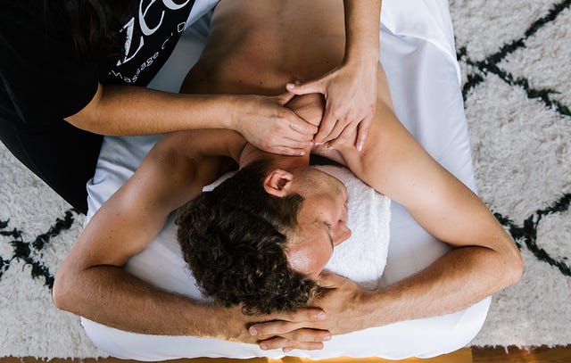 Blonde woman relaxing receiving back massage from male