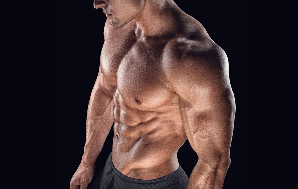 Cropped upper body of male with well defined muscles and oil on