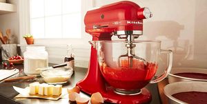 red colored kitchenaid stand mixer sitting on counter with baking supplies