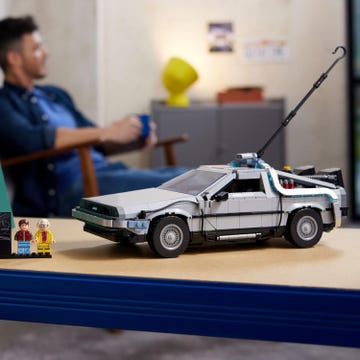 a person sitting at a desk with a toy car