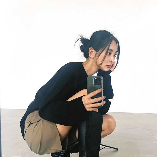 a woman sitting on the floor and holding a phone