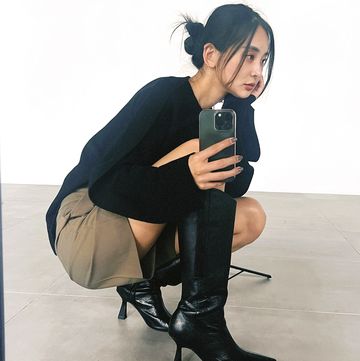 a woman sitting on the floor and holding a phone