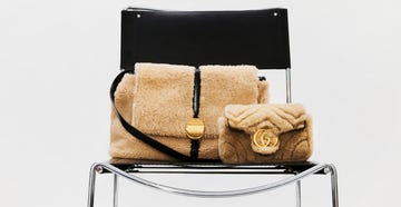 two designer handbags placed on a black chair